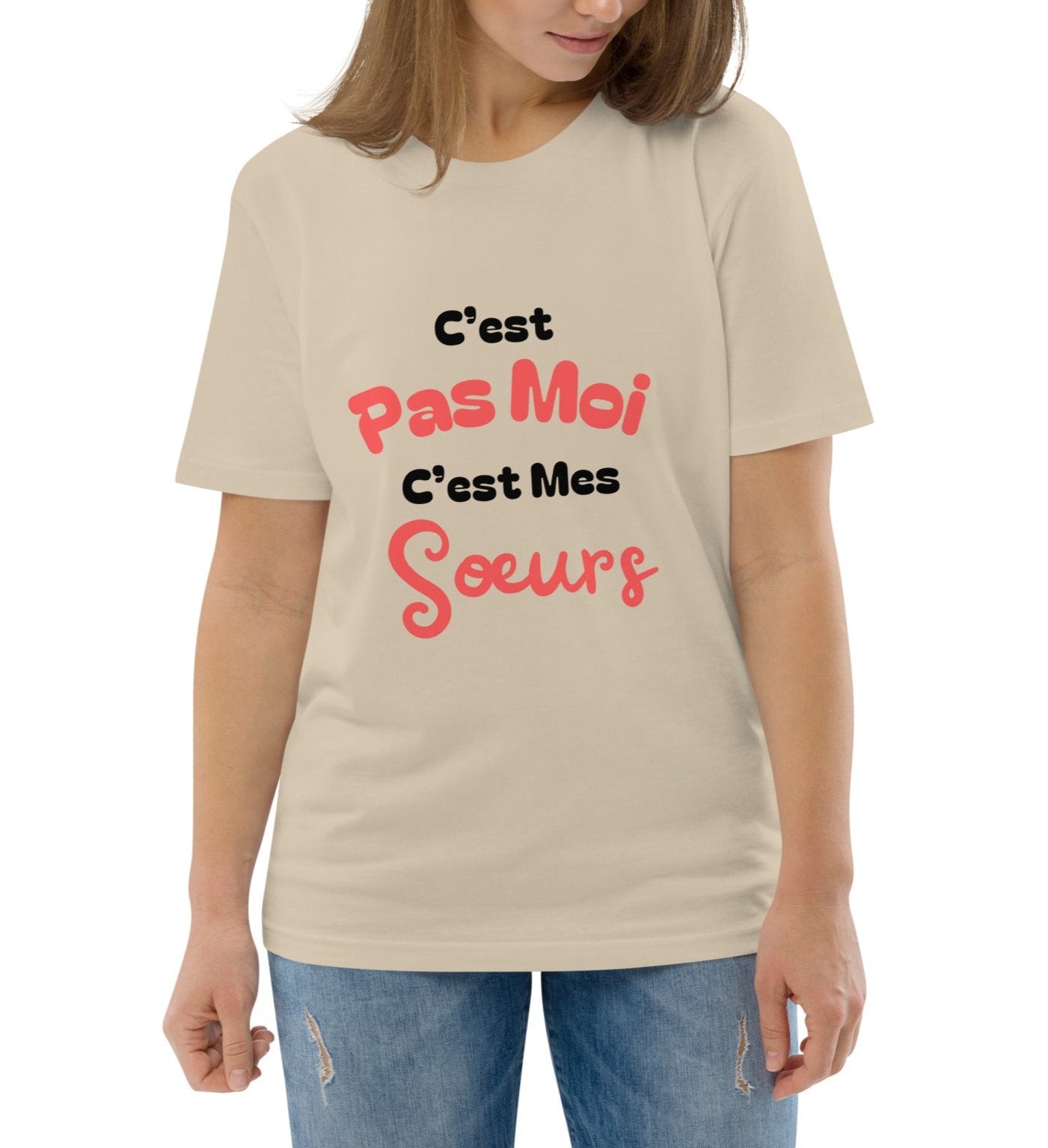 T-shirt beige col rond manche courte 100% coton bio avec inscription "C'est pas moi, c'est Mes Sœurs" porté par une mannequin