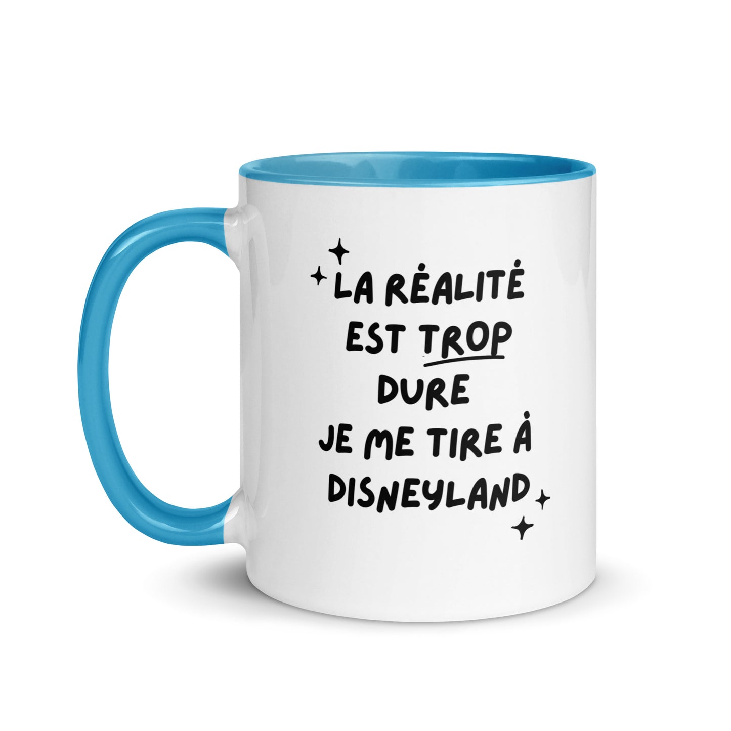 Tasse blanche brillante avec poignée, intérieur et rebord coloré bleu avec inscription "La réalité est trop dure, je me tire à Disneyland"