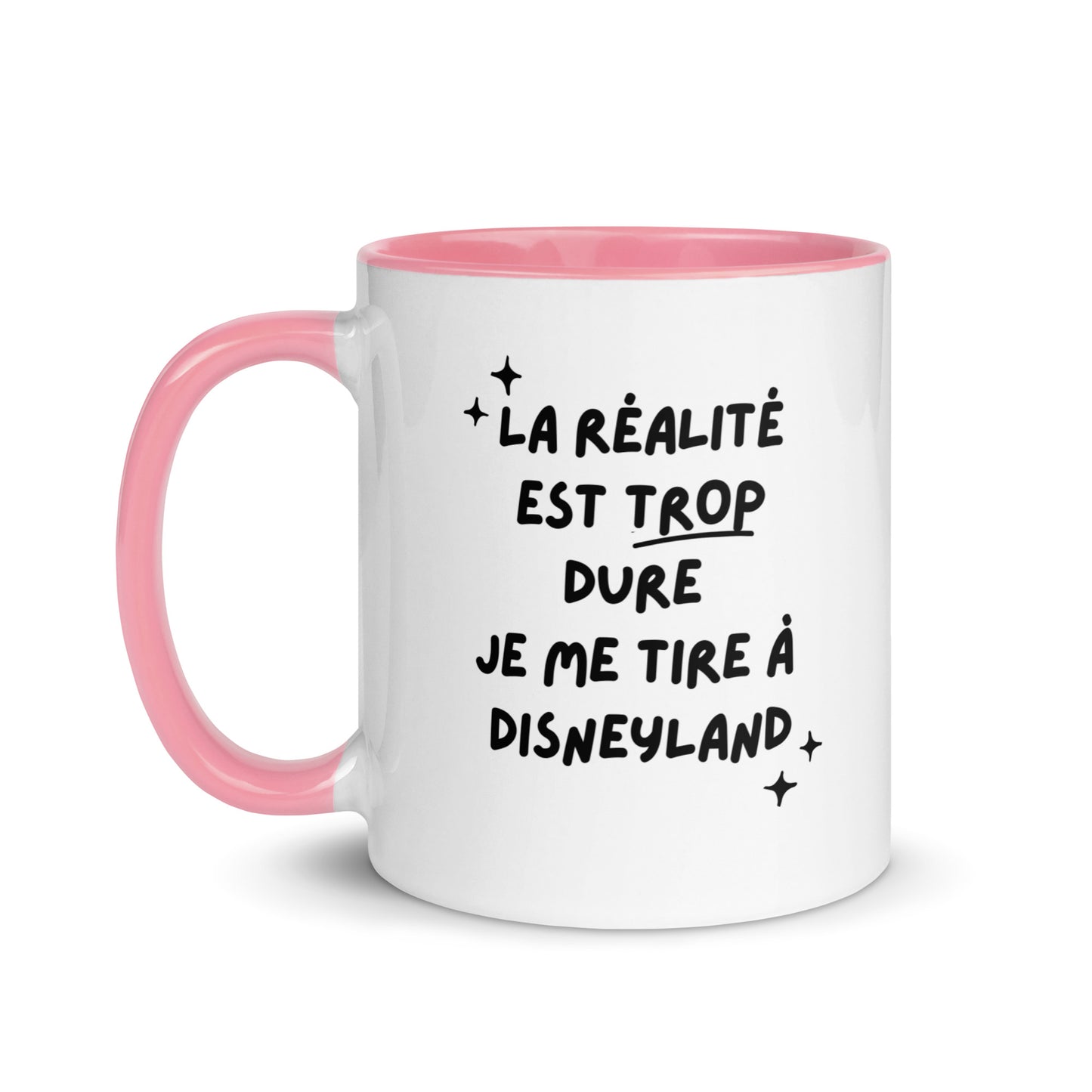 Tasse blanche brillante avec poignée, intérieur et rebord coloré rose avec inscription "La réalité est trop dure, je me tire à Disneyland"