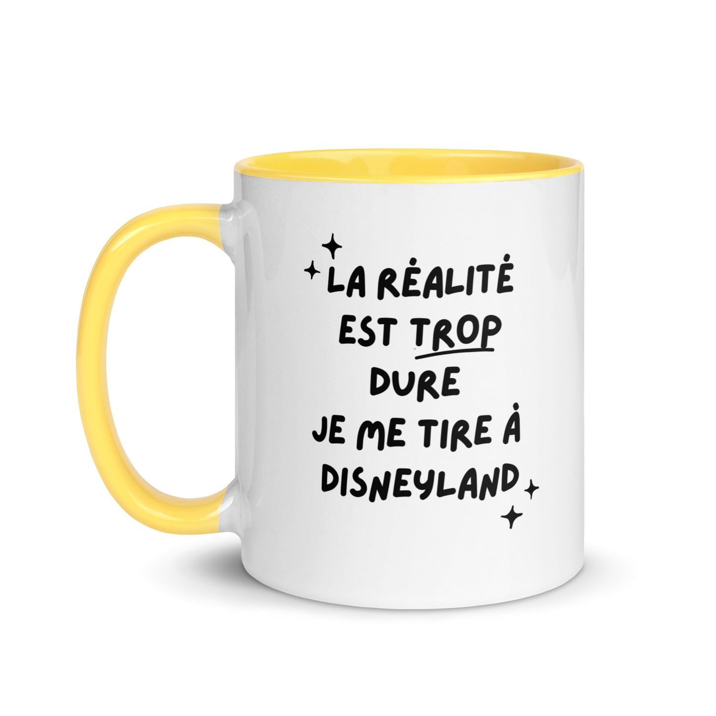 Tasse blanche brillante avec poignée, intérieur et rebord coloré jaune avec inscription "La réalité est trop dure, je me tire à Disneyland"