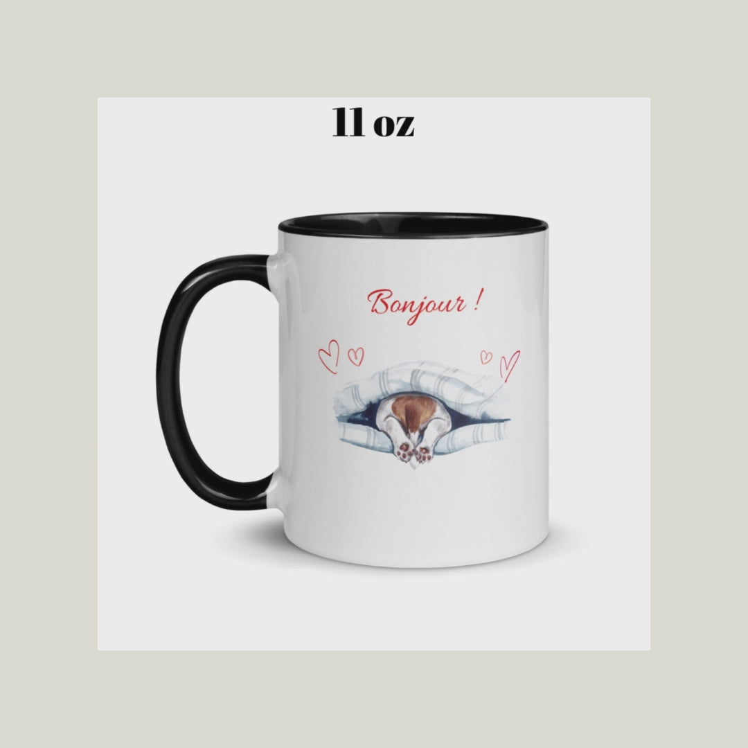 vidéo Tasse blanche avec anse, intérieur et rebord noir en céramique avec inscription "Bonjour" avec des cœurs et les pattes arrières d'un chien qui sortent de dessous sa couverture 11 oz