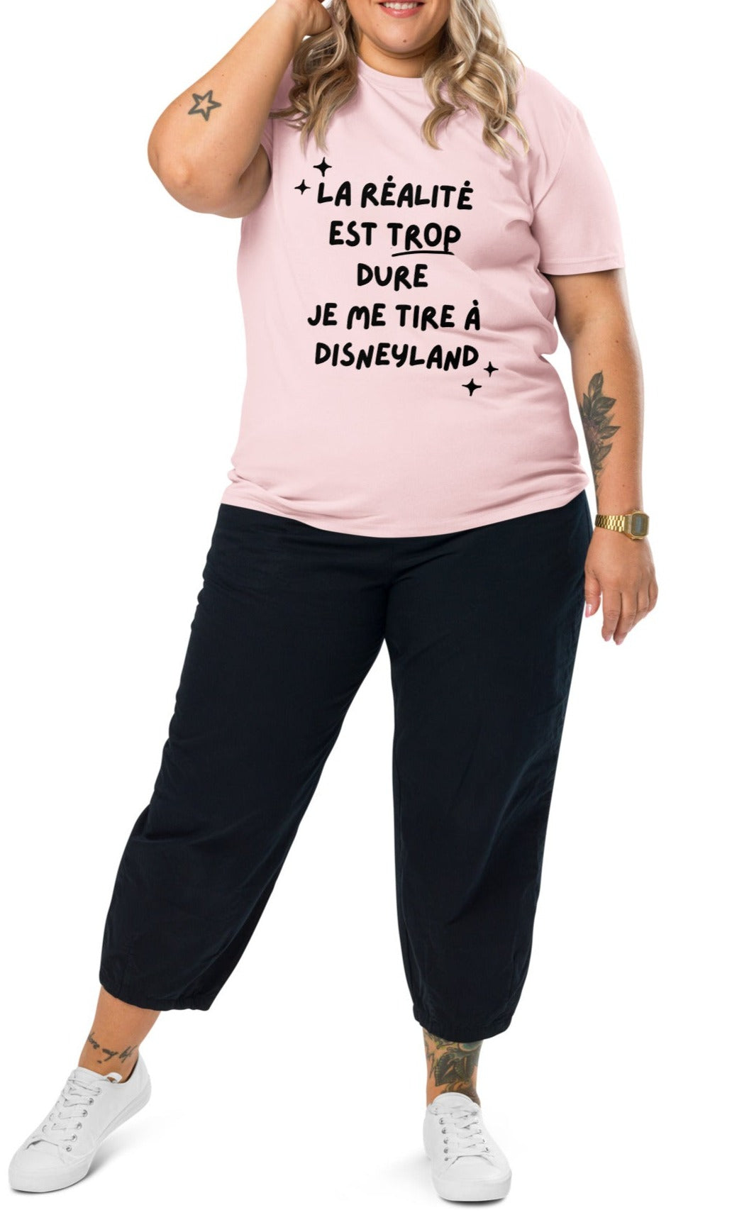 t-shirt rose clair encolure ronde manche courte en 100% coton bio avec inscription La réalité est trop dure je me tire à disneyland porté par une mannequin xxl