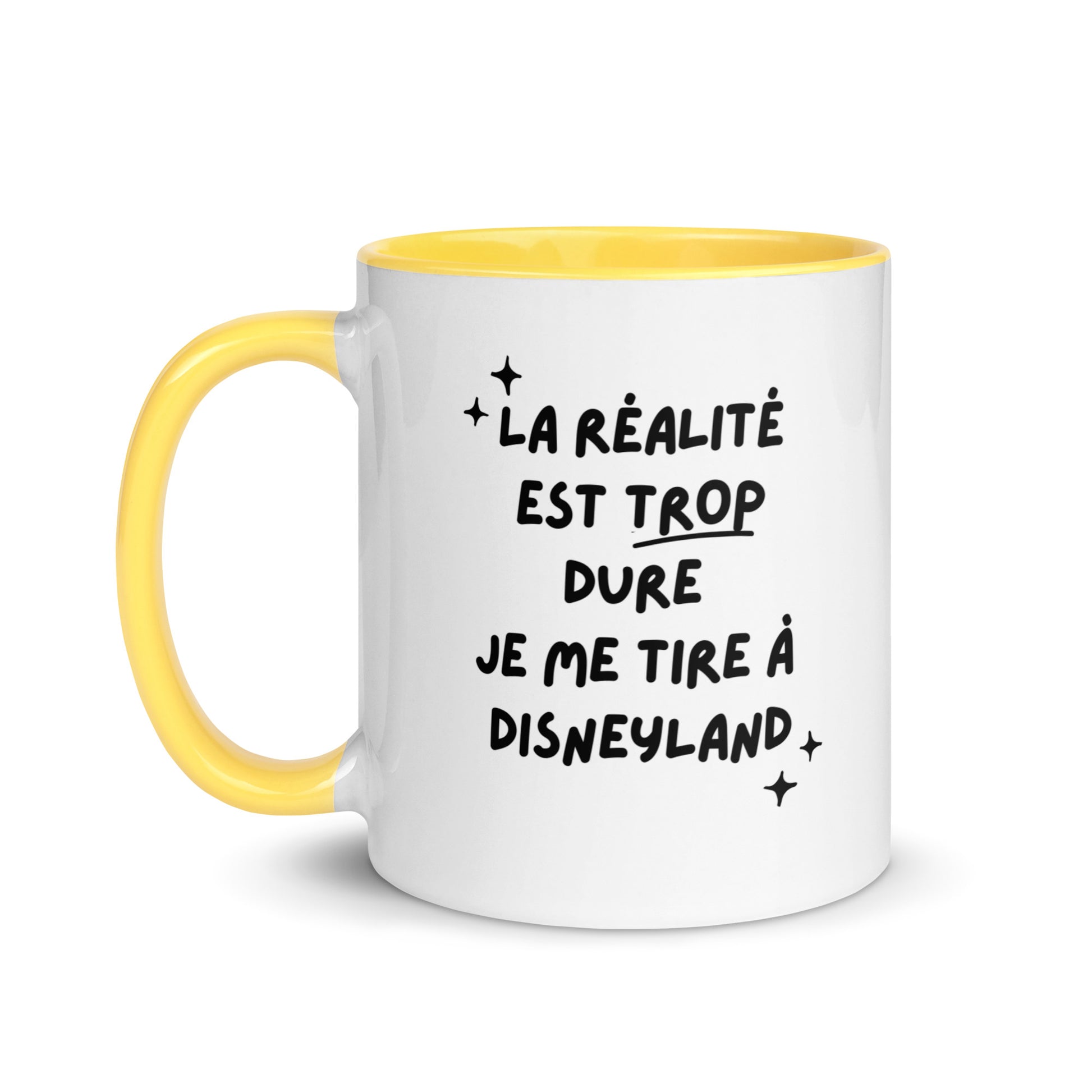 Tasse blanche brillante avec poignée, intérieur et rebord coloré jaune avec inscription "La réalité est trop dure, je me tire à Disneyland"