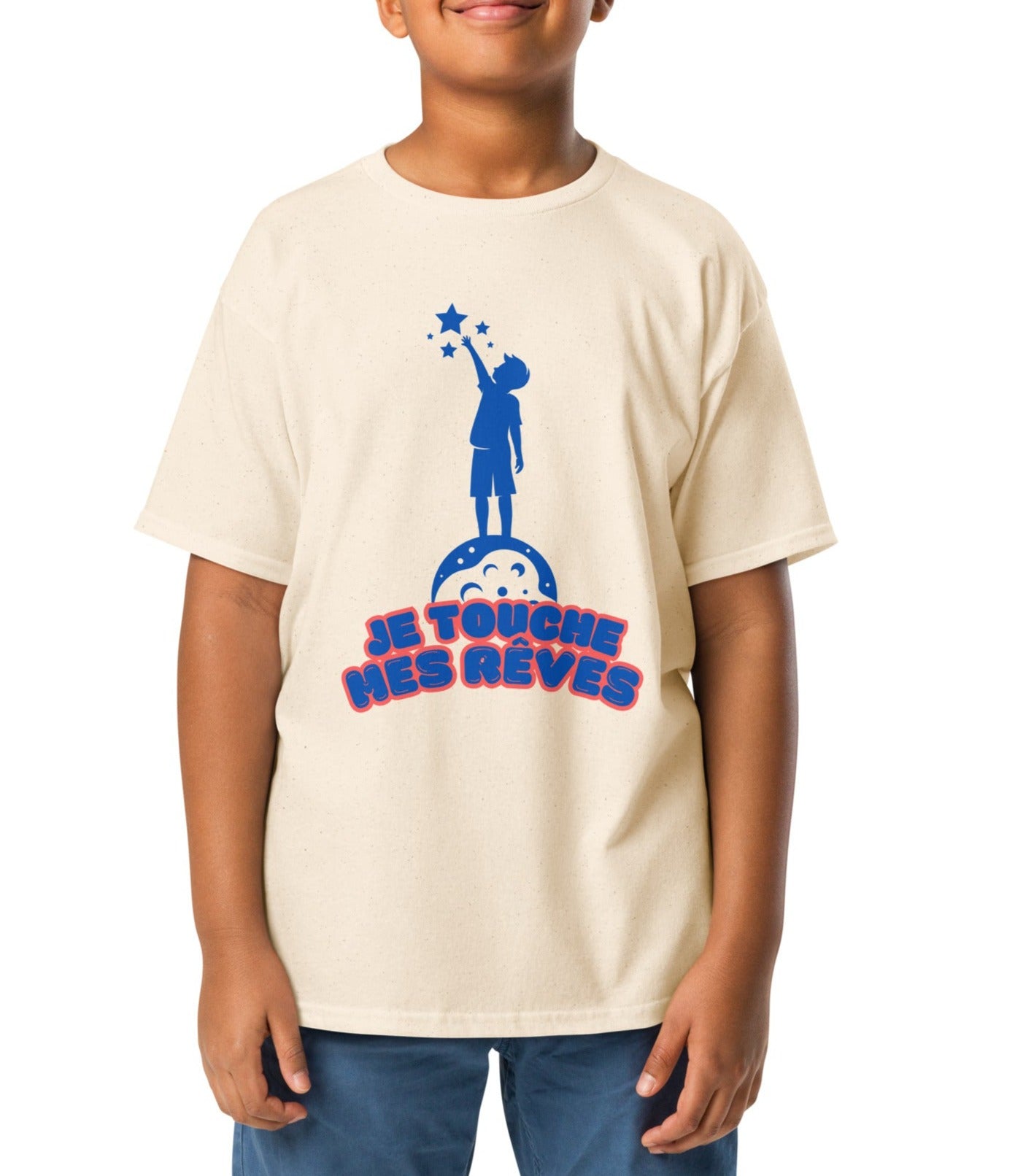 t-shirt de couleur beige clair encolure ronde manche courte dessin enfant qui touche du bout des doigts les étoiles avec inscription : "je touche mes rêves" porté par un mannequin de 10 ans 